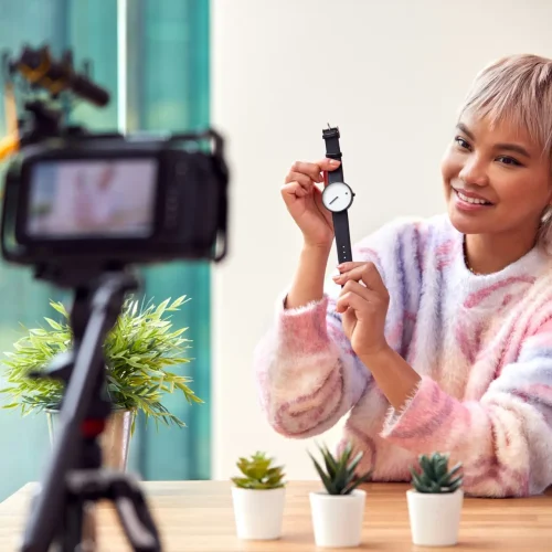 Female Vlogger Recording Wristwatch Product Review Video At Home With Camera